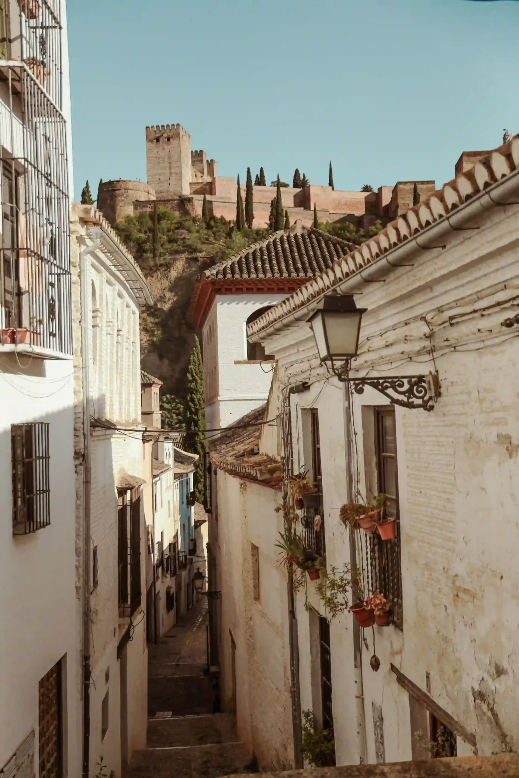 Historic streets of Granada city center with the Alhambra in the background